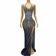 Elegant prom dress completely covered in silver rhinestones with a dramatic high split. Audre sparkling formal gown.