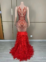 Luxury sleeveless prom dress with shining red rhinestones and a dramatic feather skirt. Ruby glamorous formal gown.