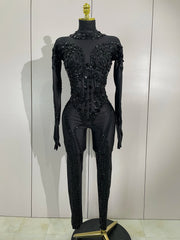Luxury sheer rhinestone mesh jumpsuit with glittering diamonds and sequins for festival or stage wear.