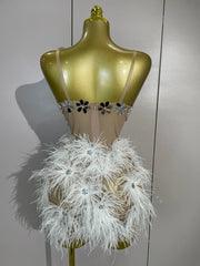 Angeli sheer mesh mini dress featuring sparkling rhinestones, decorative chains, mirror-like accents, and feather details