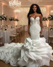 Luxurious strapless mermaid wedding dress featuring a deep sweetheart neckline, intricate beaded lace bodice, and a dramatic cascading ruffled train in elegant ivory satin.