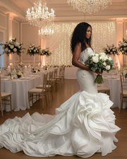 Luxurious strapless mermaid wedding dress featuring a deep sweetheart neckline, intricate beaded lace bodice, and a dramatic cascading ruffled train in elegant ivory satin.