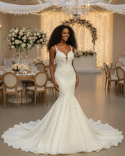 Elegant mermaid wedding dress featuring a deep illusion V-neckline, delicate lace straps, intricate beaded embroidery on the bodice, and a smooth flared skirt with a flowing chapel-length train in soft ivory.