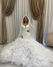 Elegant vintage mermaid wedding gown with full sleeves, pearl appliqués, and layered ruffled skirt.