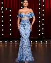 Maris off-the-shoulder gown with 3D floral appliqué and fishbone corset, styled for weddings and high-formality events.