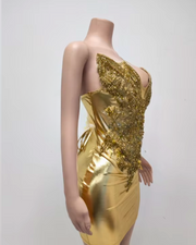 Gold strapless off-the-shoulder dress with crystal embellishments and sculpted fitness silhouette, styled for glamorous occasions.