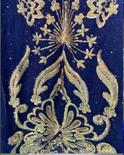 Navy blue off-shoulder quinceañera dress with gold appliqués, crystal embellishments, and full princess skirt.