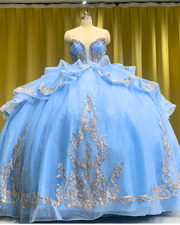 Sky blue quinceañera dress with rose gold appliqués, fitted bodice, and full princess skirt.