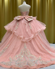 Dusty rose pink sparkle quinceañera ball gown with iridescent scrollwork appliqués.