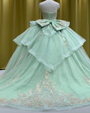 Mint green glitter quinceañera ball gown with rose gold appliqué and crystal corset bodice.