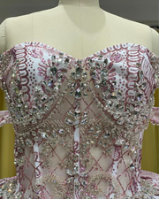 Off shoulder white and rose gold quinceañera ball gown with crystal bodice.