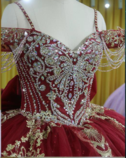 Burgundy Quinceañera dress with crystal tassels, spaghetti straps and corset bodice