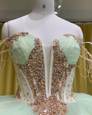 Mint and rose gold quinceañera gown with tulle skirt, rose gold appliqués, and fitted bodice.