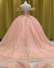 Blush pink quinceañera gown with gold beading, fitted bodice, and full princess skirt.