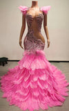 Pink mermaid gown with feathered cap shoulders, illusion cut-outs, and tiered ostrich feather skirt