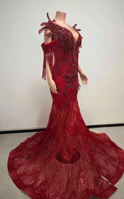 Ruby red beaded mermaid gown with sculptural chest fin details, sequin fringe off-the-shoulder sleeves, and floor-length illusion train