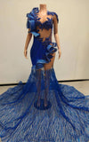 Royal blue mermaid gown featuring sculptural organza ruffles and a glittering mesh train, fitted silhouette with dramatic flare