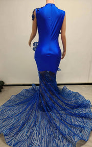 Royal blue mermaid gown featuring sculptural organza ruffles and a glittering mesh train, fitted silhouette with dramatic flare